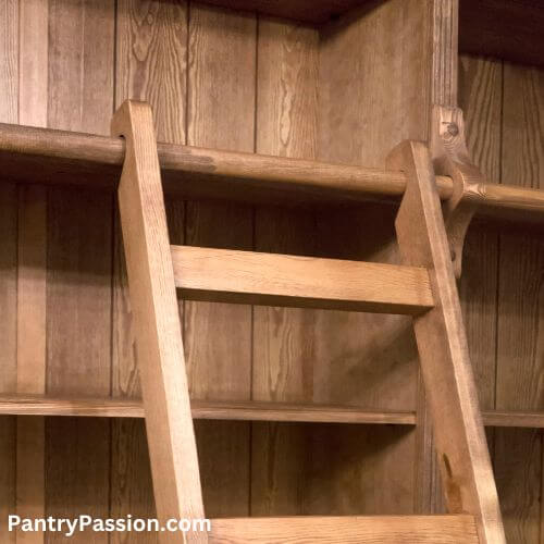 Wood library ladder with notched top designed to place on railing.