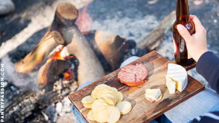 camper enjoying a no cook camping meal next to campfire