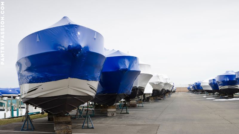 Wrapped boats with blue plastic, winterized for storage.