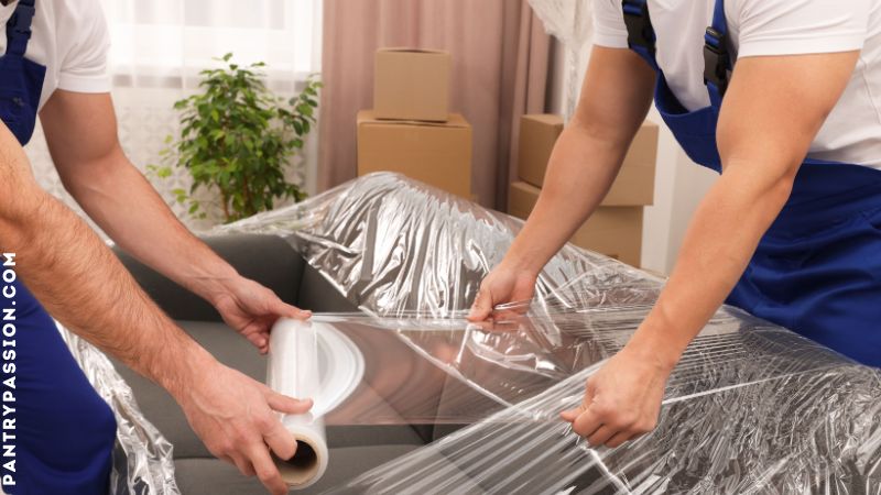 Workmen wrapping furniture for storage.